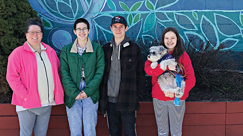 Melodee Bourdeau, Emma, Roger, and Sophie holding Rosie at the mural in Ypsilanti that Emma helped paint. 