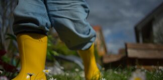 yellow rain boots in field of grass